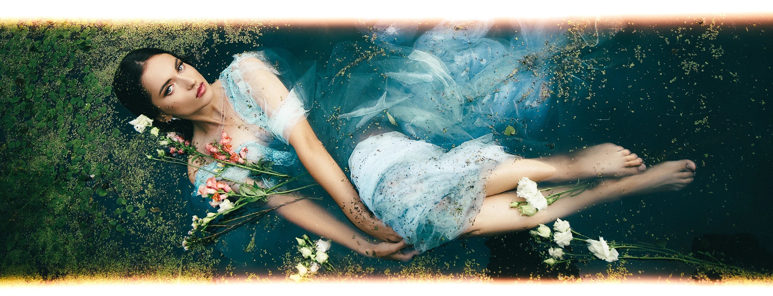 AI Preset Lab Ilfocolor Rapid Retro Disposable Film Lightroom Preset on fashion portrait in blue dress lying in water with flowers.