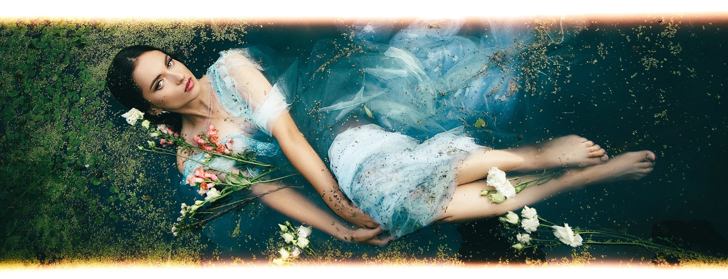 AI Preset Lab Ilfocolor Rapid Retro Disposable Film Lightroom Preset on fashion portrait in blue dress lying in water with flowers.
